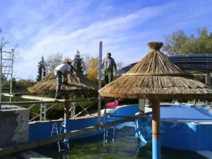 Napernyő jellegű nádtetős hűsölő pihenőkertben